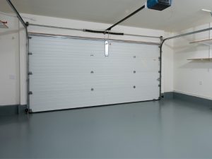 Empty garage with a smooth, grey DIY epoxy floor, showcasing the suitability of DIY epoxy floors for high-traffic areas.