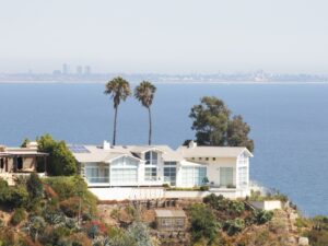 Modern coastal house with large windows and ocean view, showcasing the best house painting in a seaside environment.