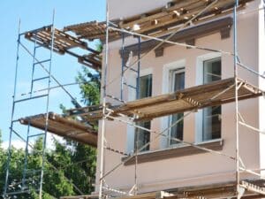 Scaffolding set up around building to address flaking paint issues on exterior surfaces.