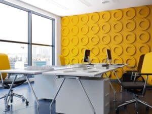 Office space with bold yellow circle-patterned wall illustrating vibrant office painting ideas for creativity.