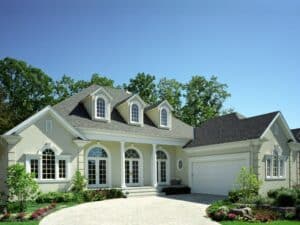 Classic suburban house with arched windows, showcasing paint durability in maintaining a fresh, elegant exterior finish.