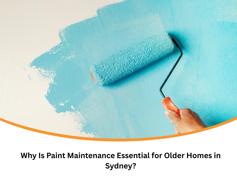 A hand uses a paint roller to apply blue paint to a wall. Essential paint maintenance for older Sydney homes.