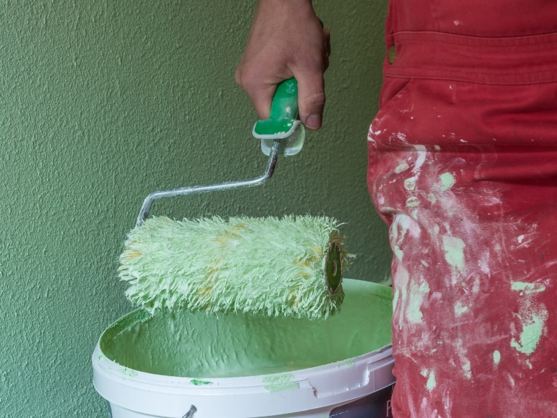 Low Cost Painters using green paint and a roller.