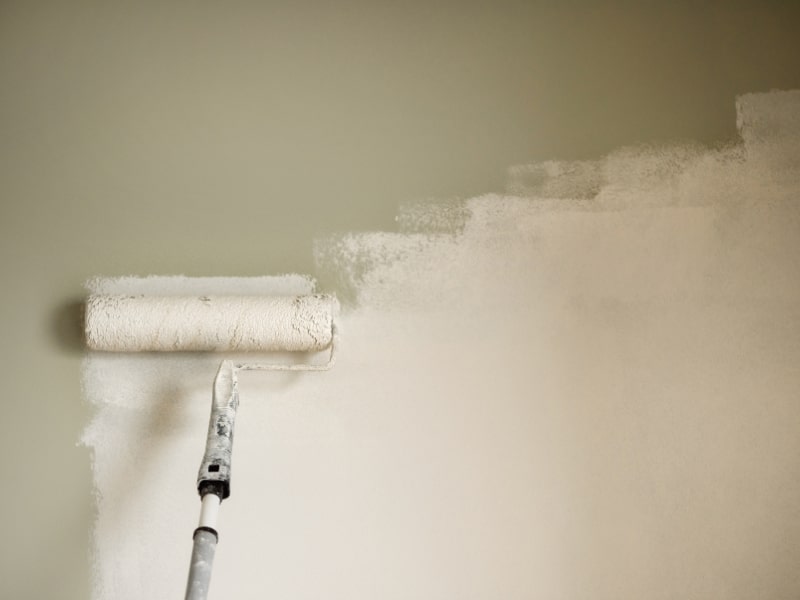 Painters Southern Highlands using roller to apply fresh white paint on indoor wall
