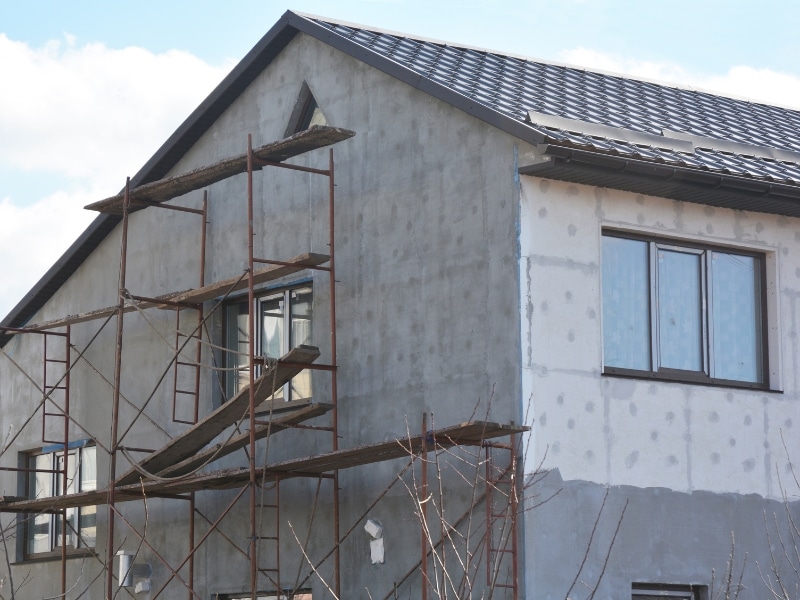 House under construction with grey render before choosing exterior walls paint colours