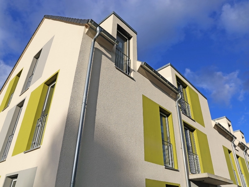 Apartment building exterior highlighting strata colours with green and beige panels