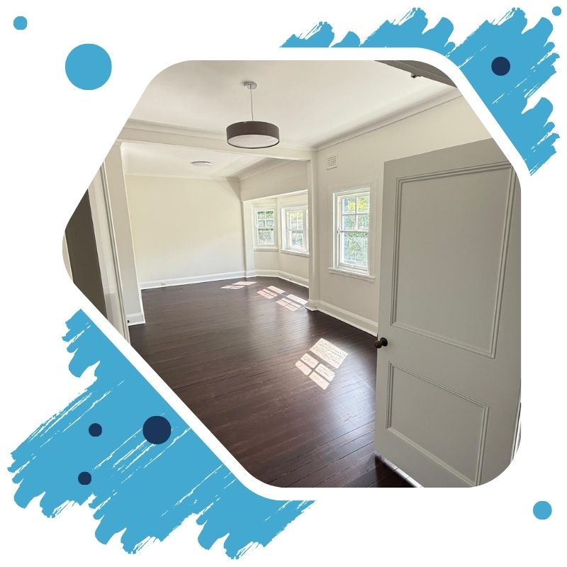 Gloved hand using roller to paint interior wall grey — professional Painting Services for smooth, clean finishes.