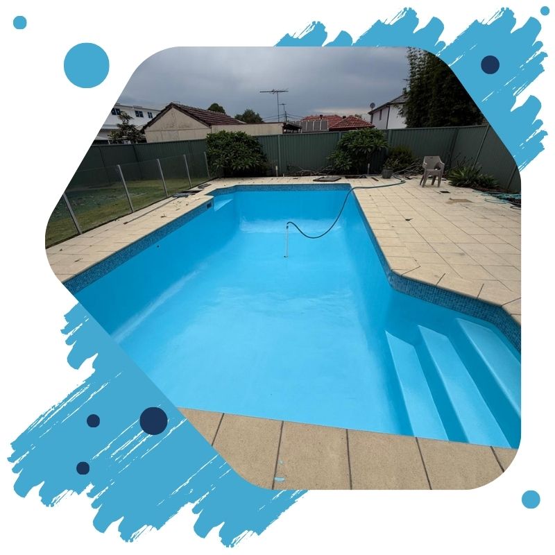 Close-up of a repainted swimming pool in Sydney with a shiny blue epoxy finish and stainless steel ladder.